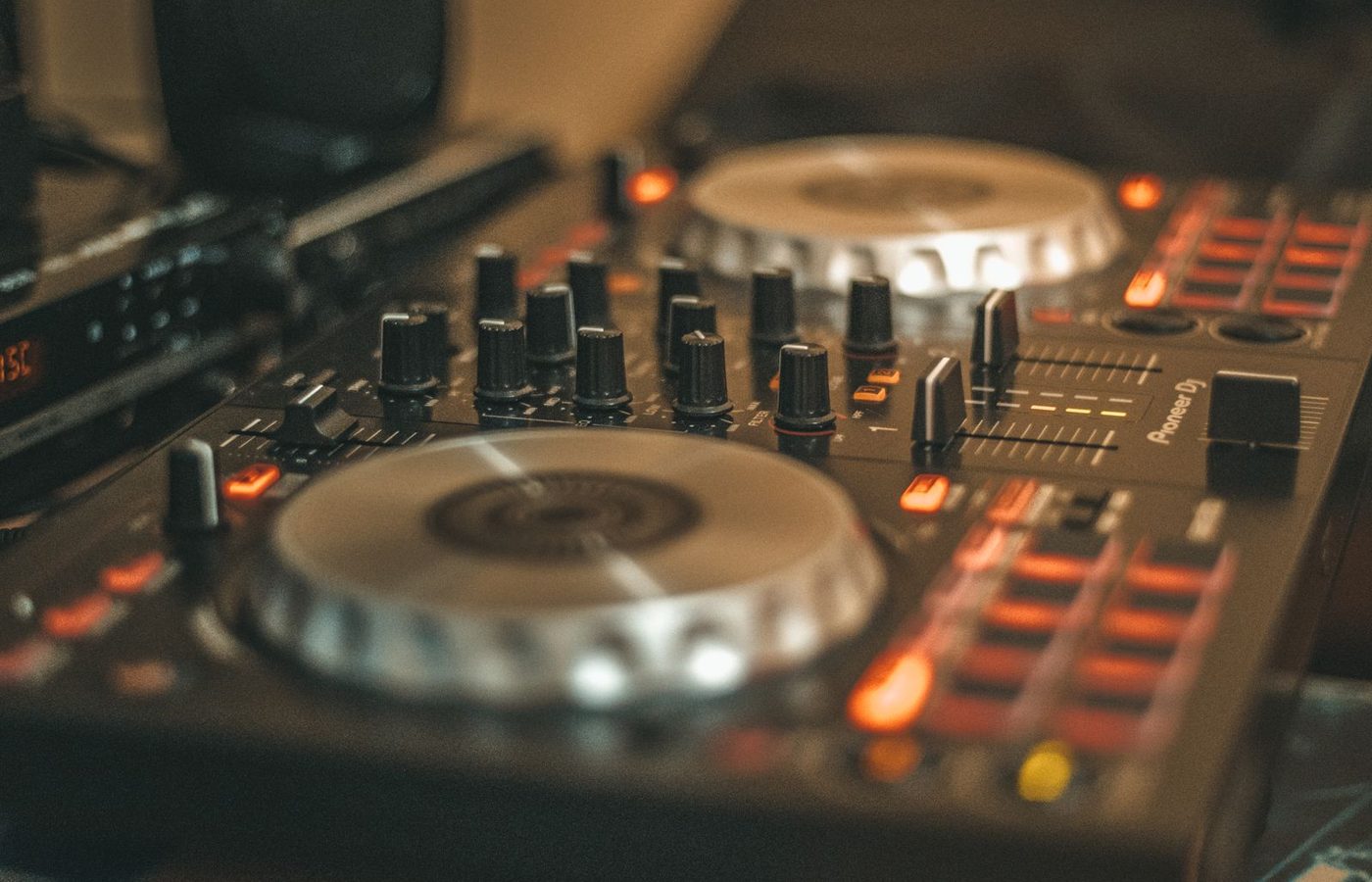 Close-up of a DJ controller's glowing jog wheel and performance pads