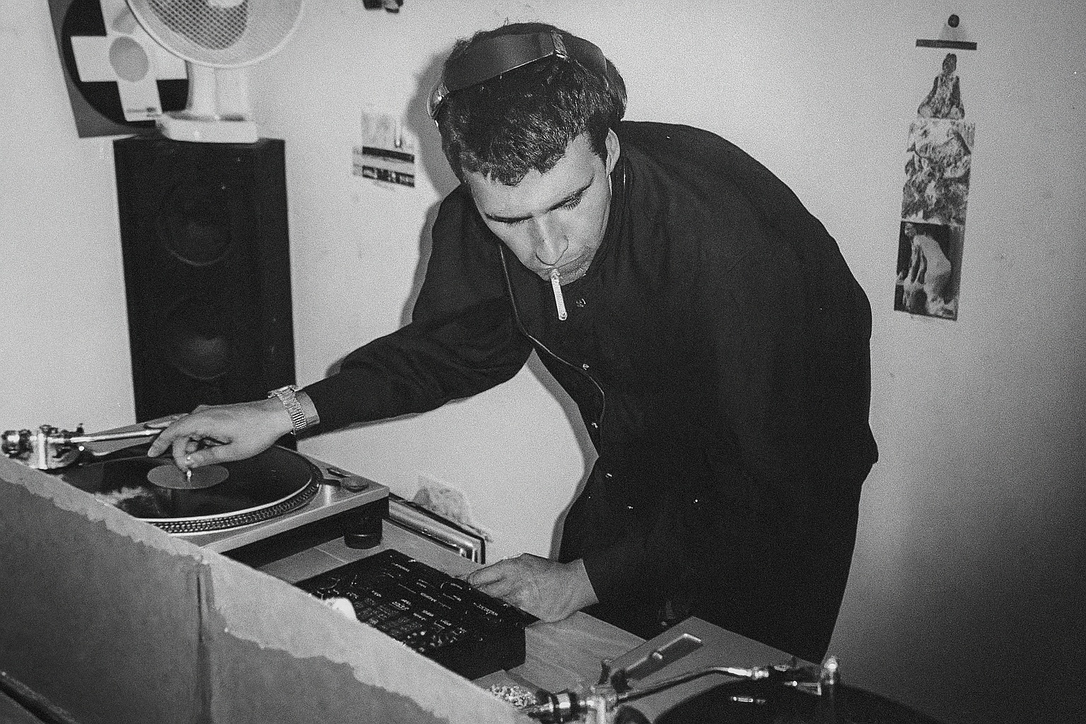 John behind a pair of Technics turntables in the mid-1990s, cueing a record